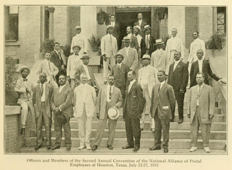 Officers and members of the Second Annual Convention of the National alliance of Postal Employees at Houston, Texas. July 23-27, 1915. Twenty seven Black men in suits pose for a picture on the steps of an unknown brick building.